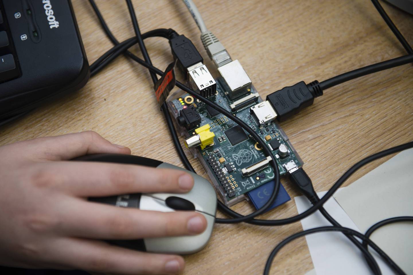 Teenagers at a computer workshop writing code and learning to programme Raspberry Pi simple single-board computer