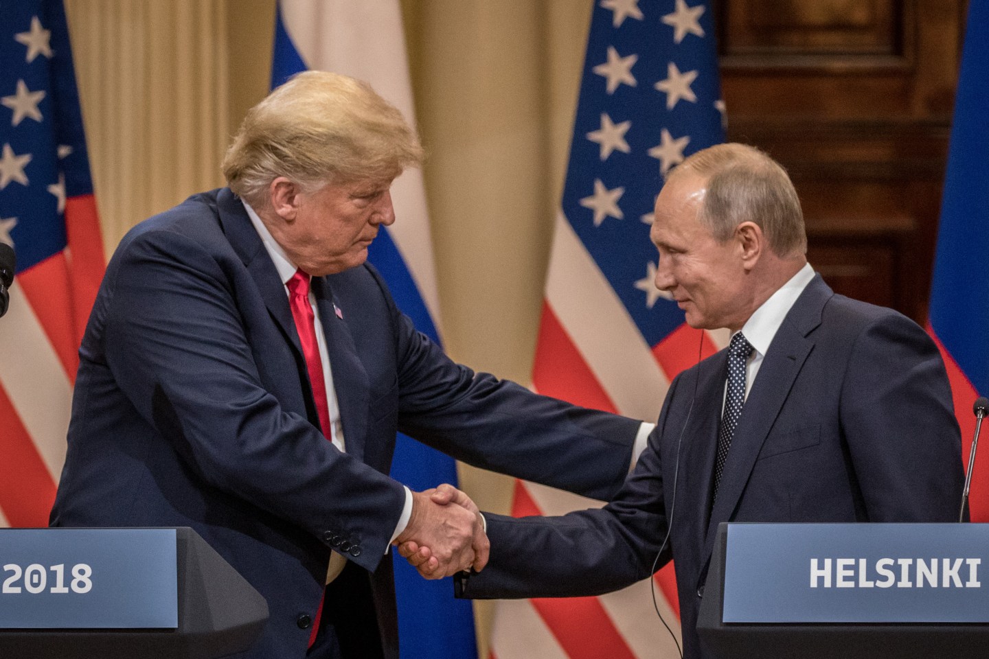 President Donald Trump and Russian President Vladimir Putin shake hands.