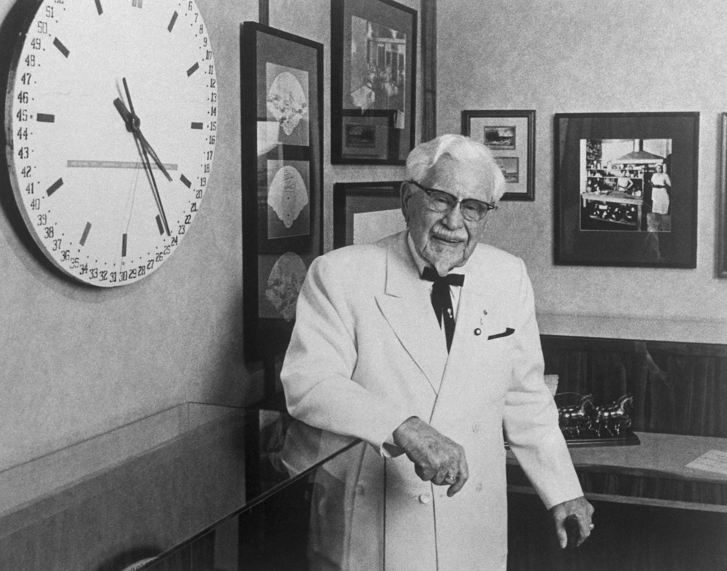 Colonel Harland Sanders Standing by Wall Clock