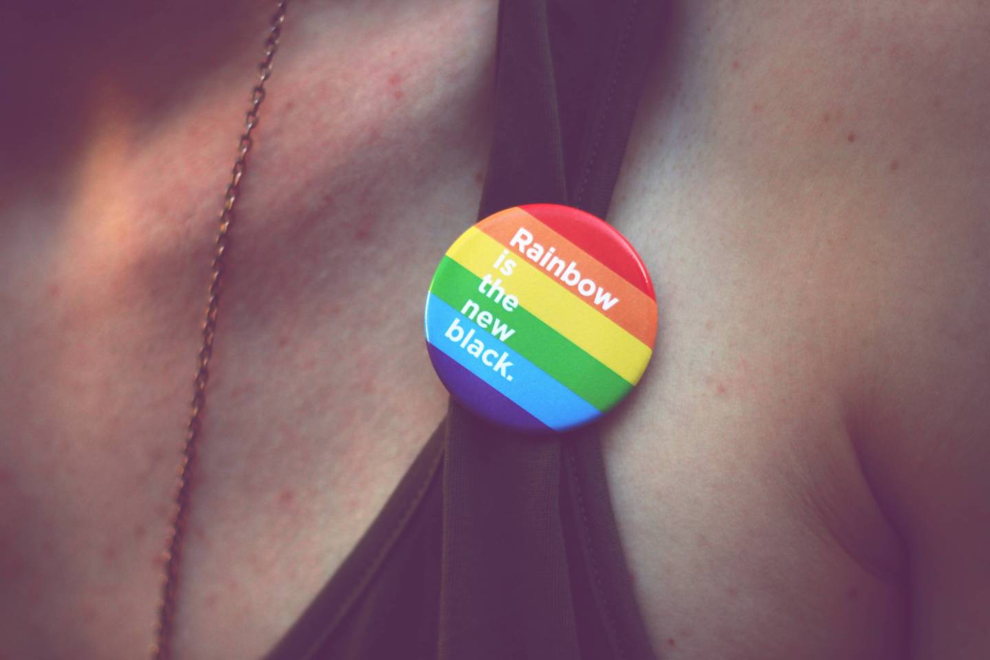 Close-Up Of Midsection Of Man Wearing Rainbow Badge With Message