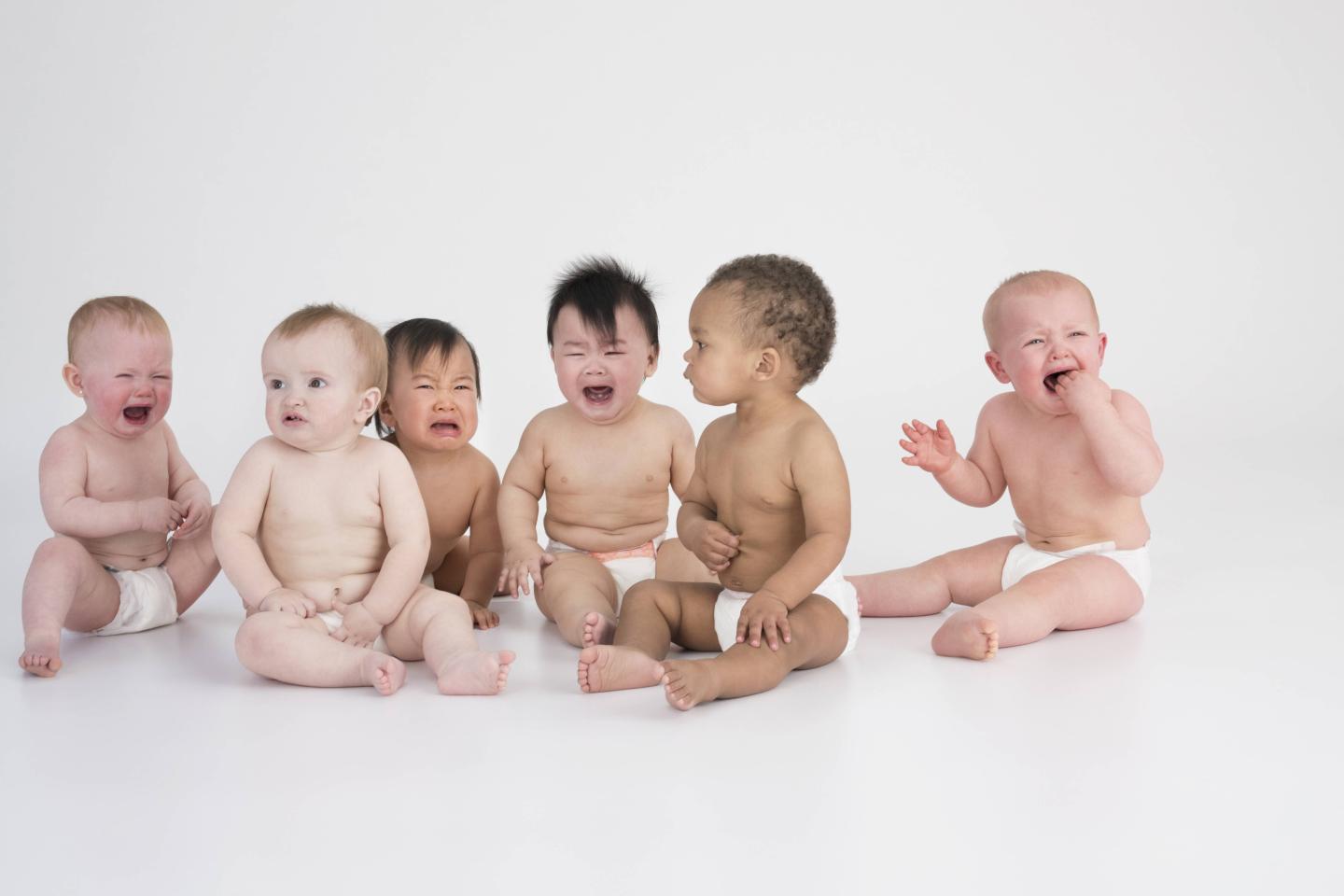 Crying babies sitting on floor