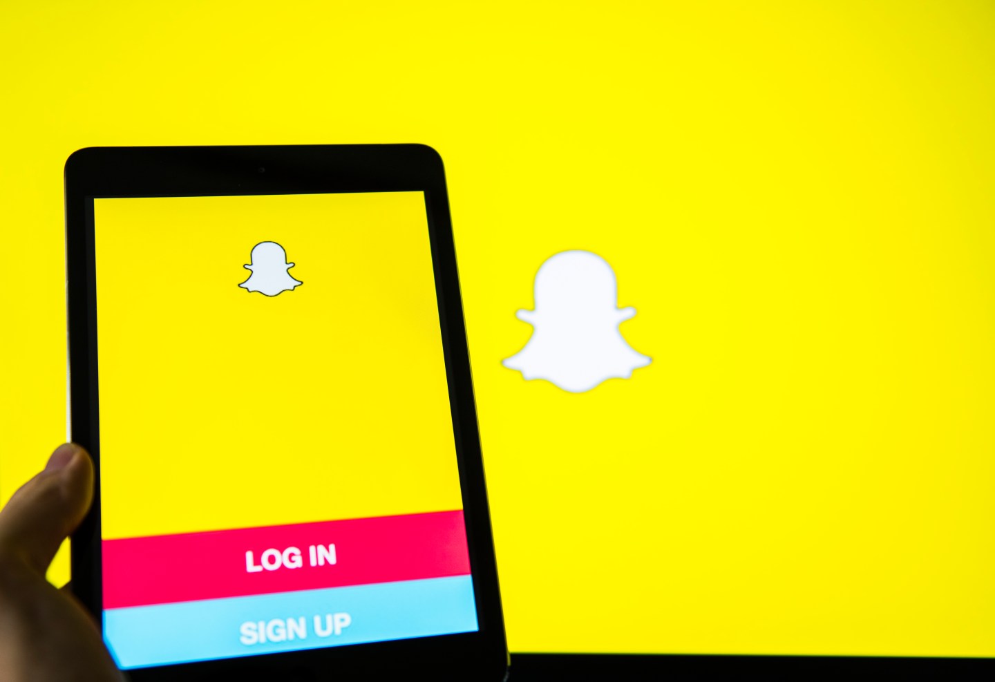 Young man holds a smart device while using SnapChat app