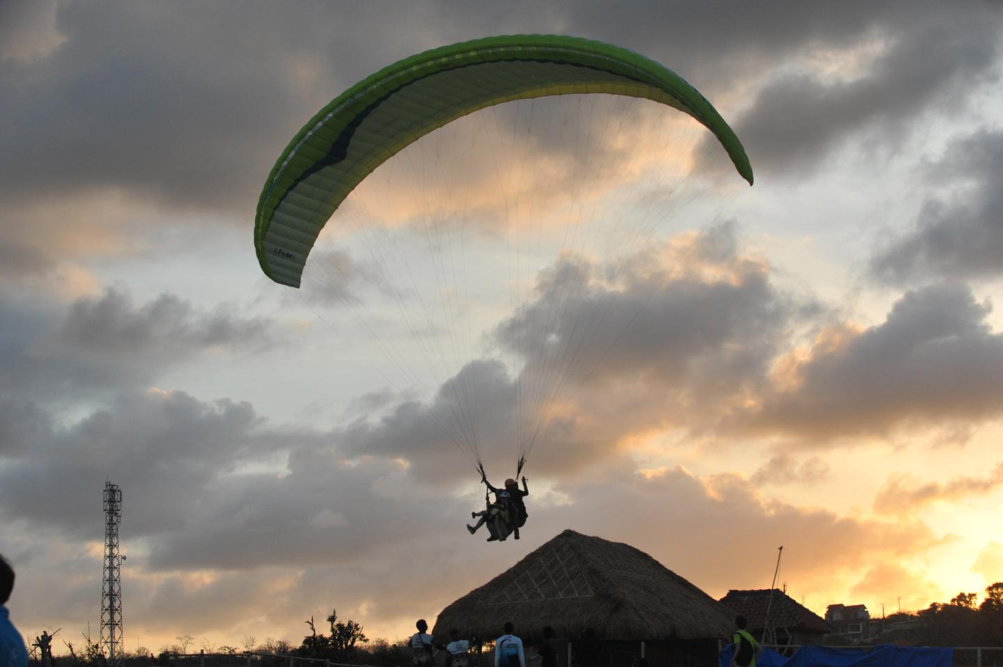 Tourists fly joint paragliding in Nusa Dua