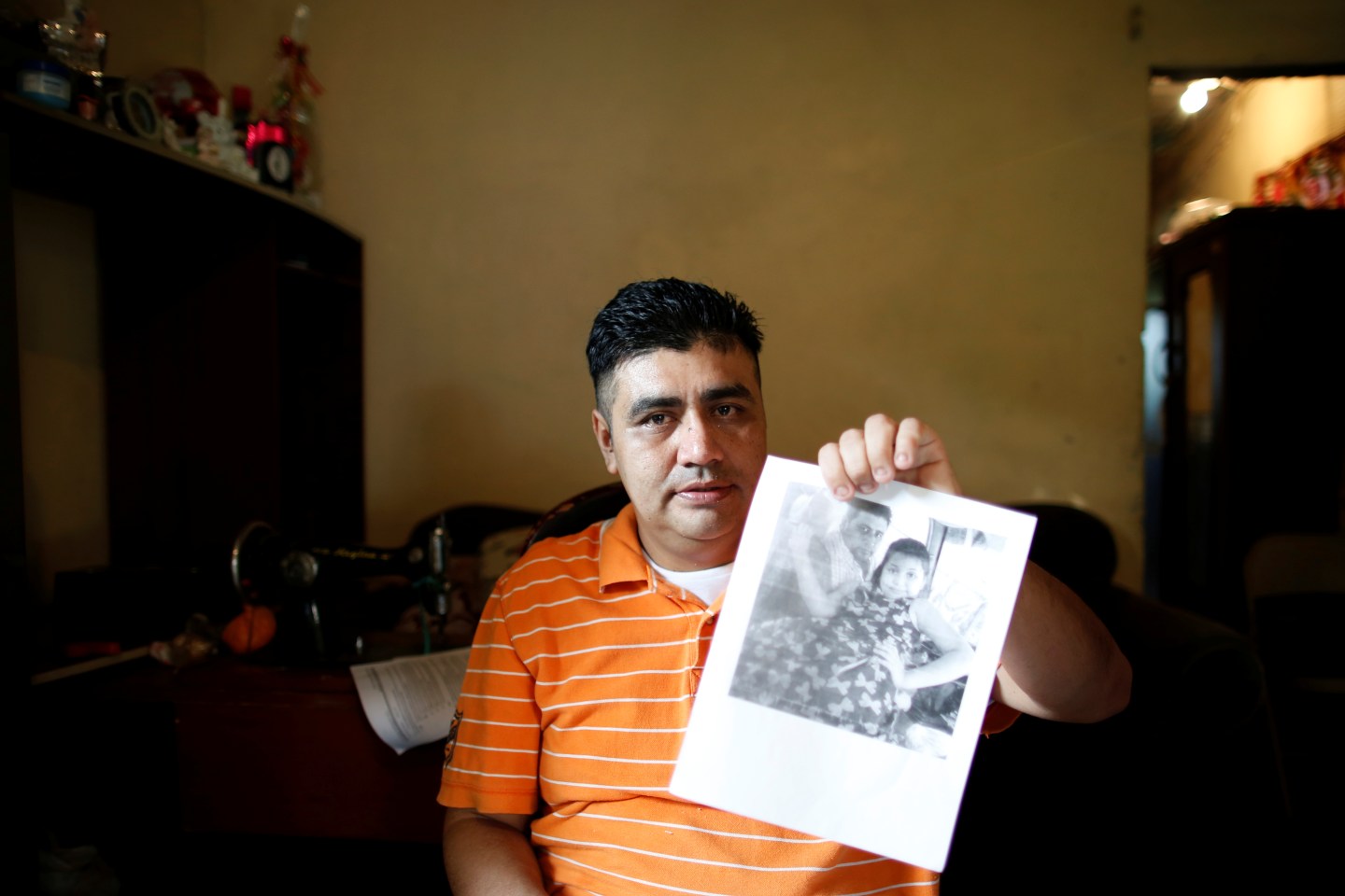 Melvin Garcia, a deportee from the U.S. who was separated from his daughter Daylin, shows a photo of his daughter during an interview with Reuters in Choloma, Honduras