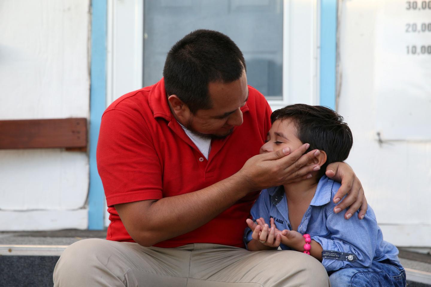 An asylum seeker from El Salvador and his young son arrive at a shelter in San Benito after he said they were reunited following separation since late May while in detention