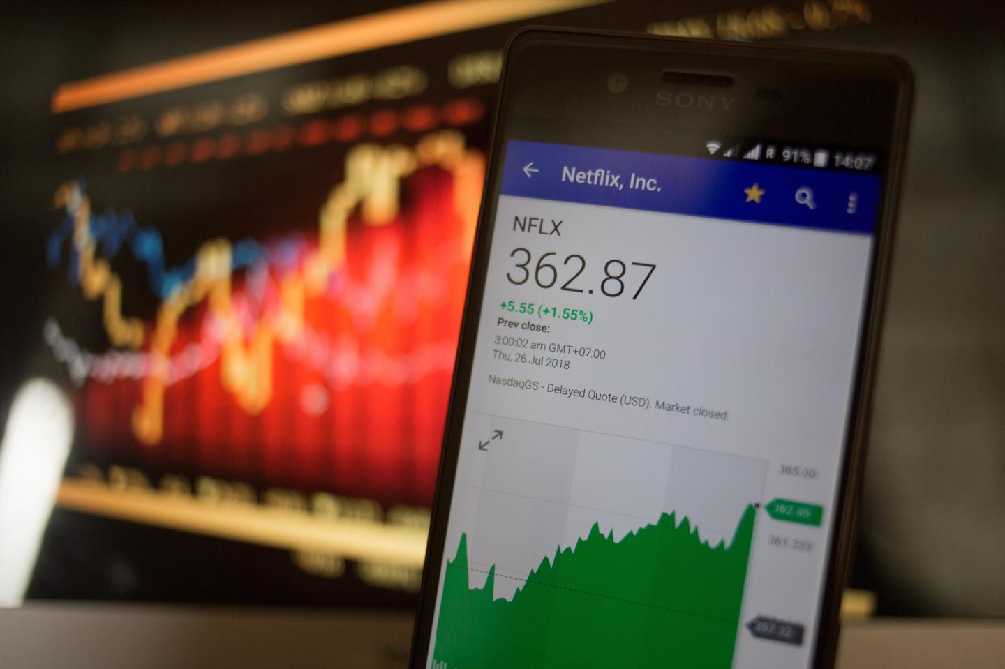A smartphone displays the Netflix, Inc. market value on the