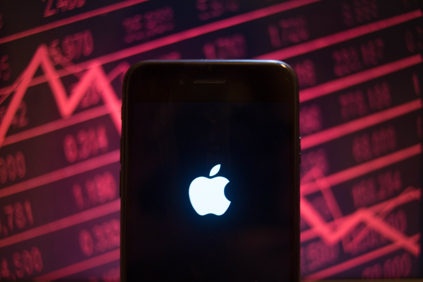 An iPhone displays the Apple logo with a background of a