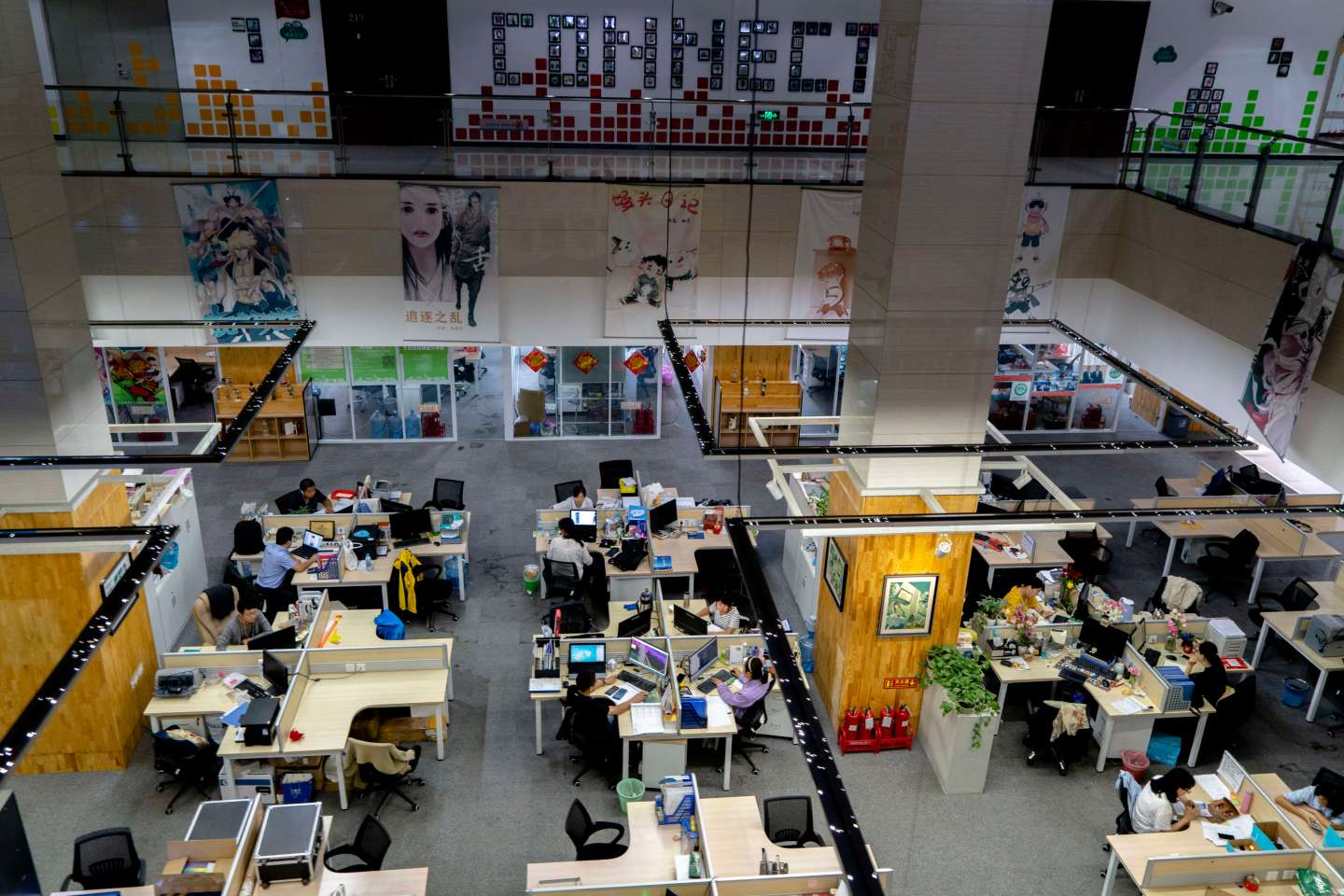 Young people are working in an open office space, which is a