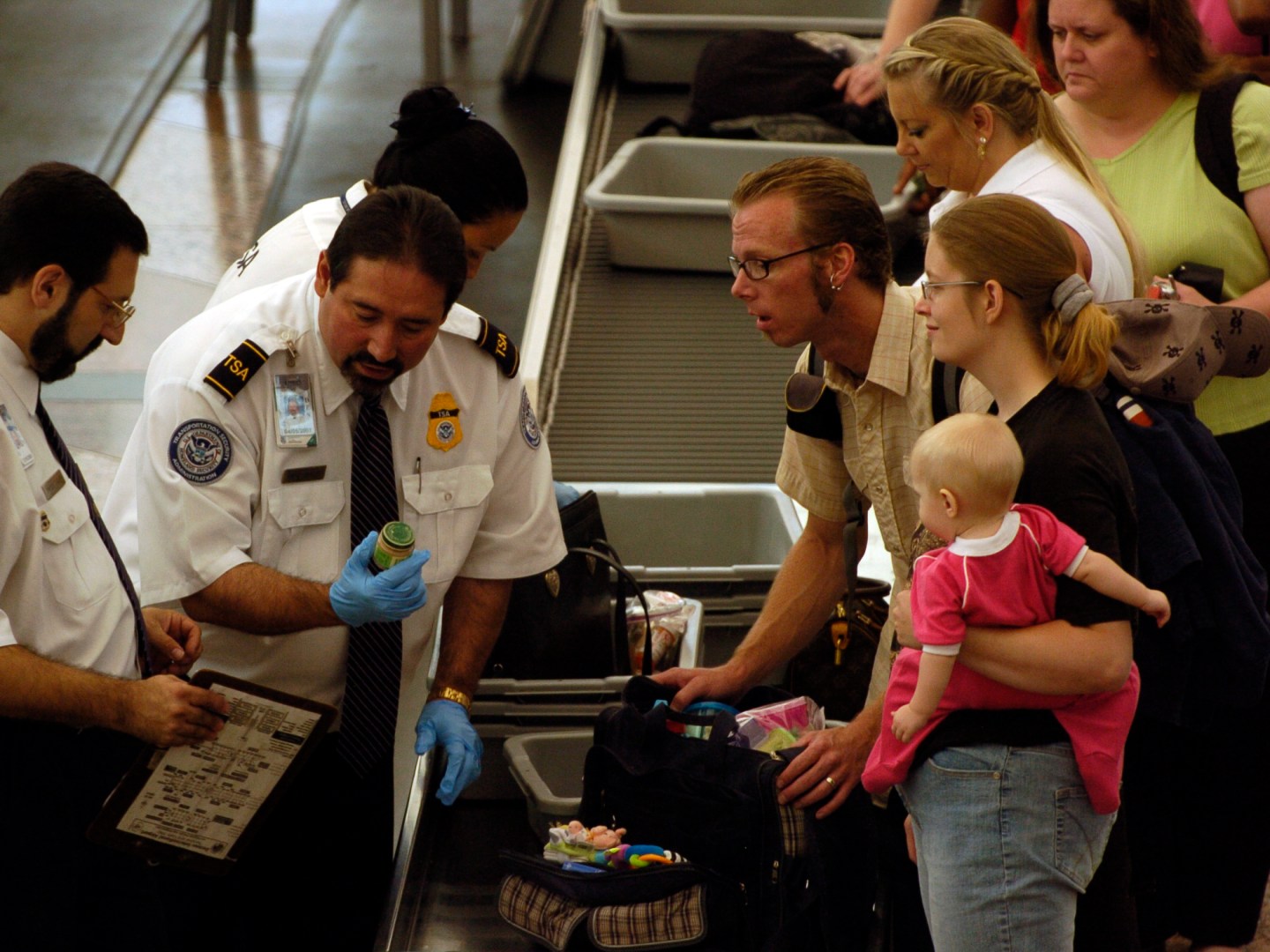 Transportation Security Administration screeners examine and then confiscate bottles of baby food from the carry-on luggage of travelers prior to a flight from Denver International Airport, Thursday, Aug. 10, 2006, in Denver. The airport experienced long
