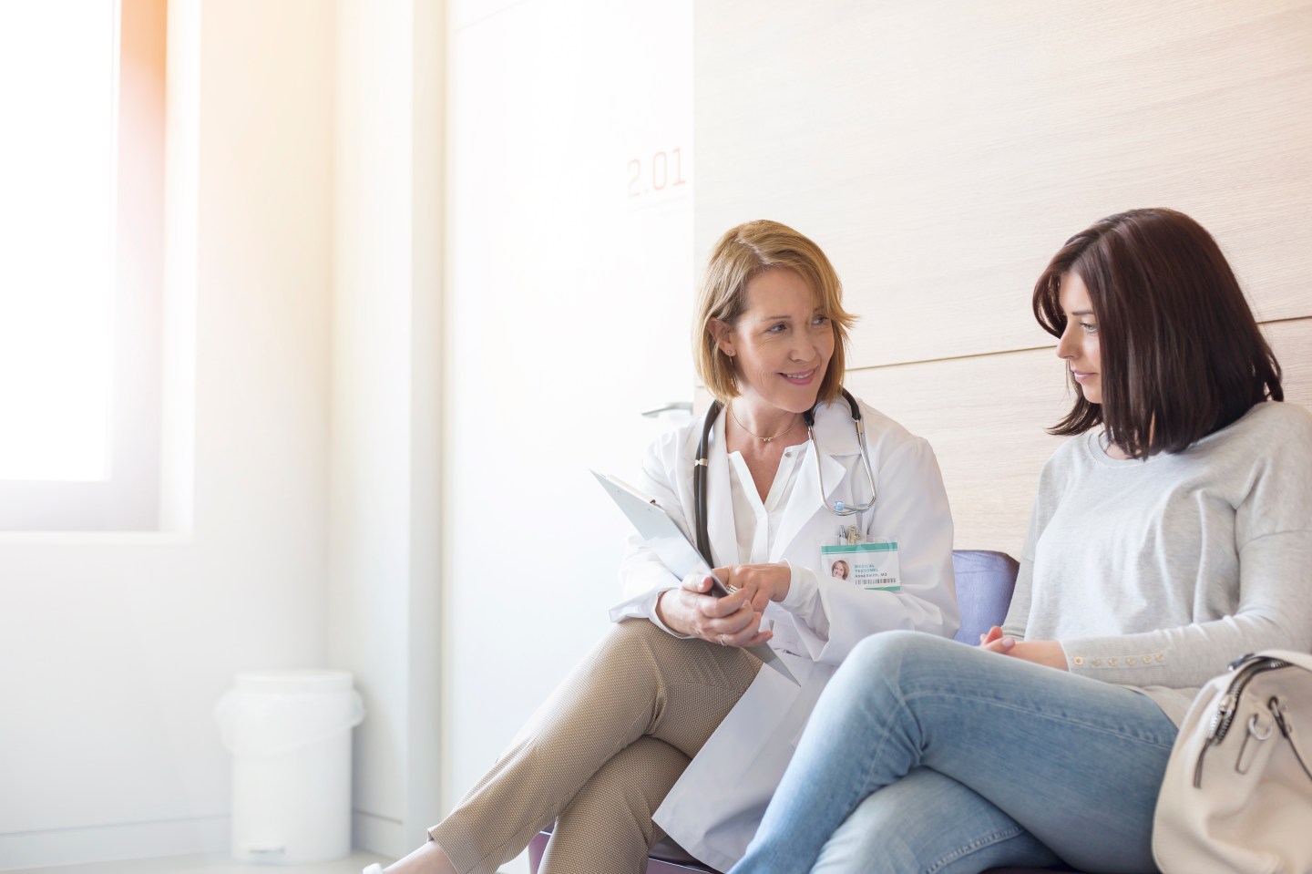 Doctor and patient reviewing medical record in clinic lobby