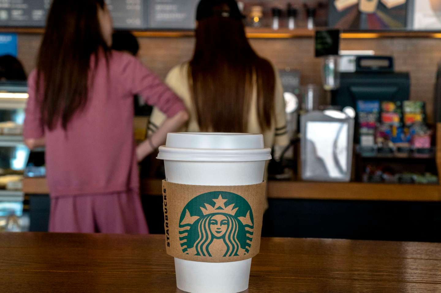 Young girls buy coffee in a Starbucks shop.  During the