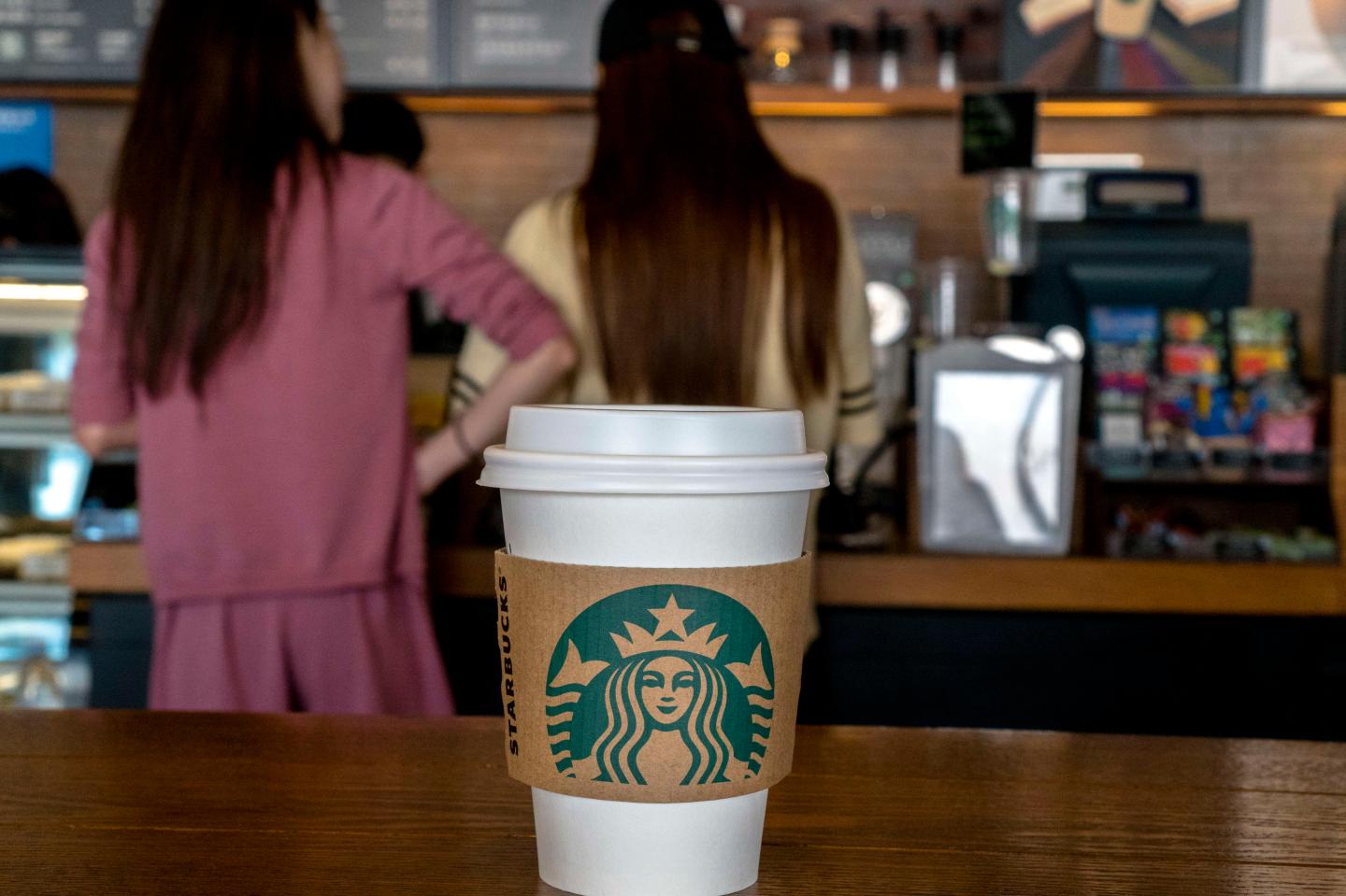Young girls buy coffee in a Starbucks shop. During the
