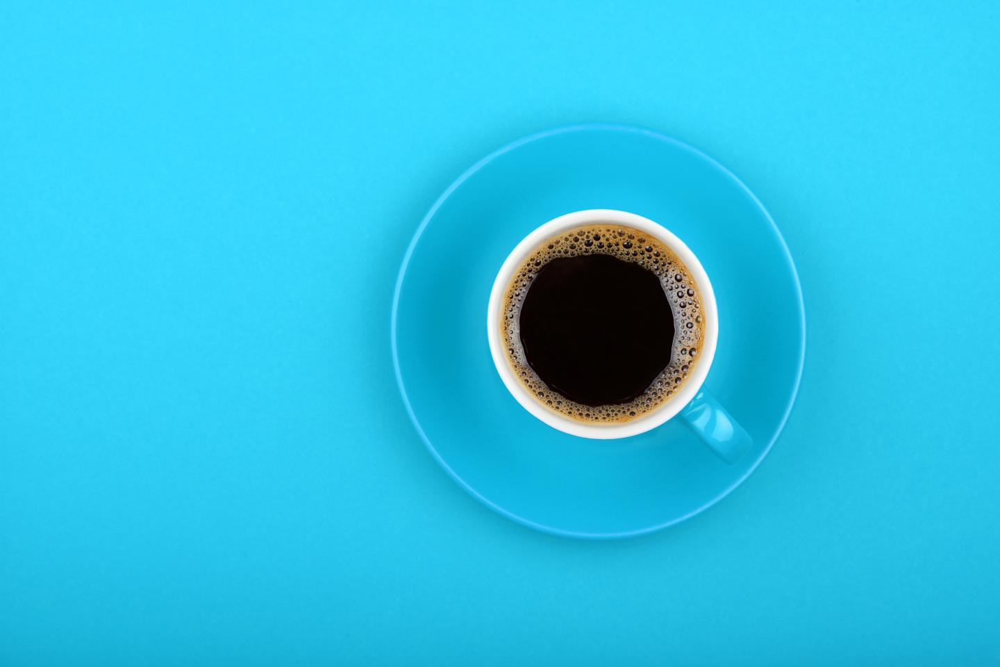 Directly Above View Of Black Coffee In Cup On Blue Background