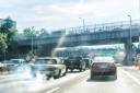 Road and street highway in NYC with sign for George Washington Bridge, smoke coming out of exhaust pipe of car