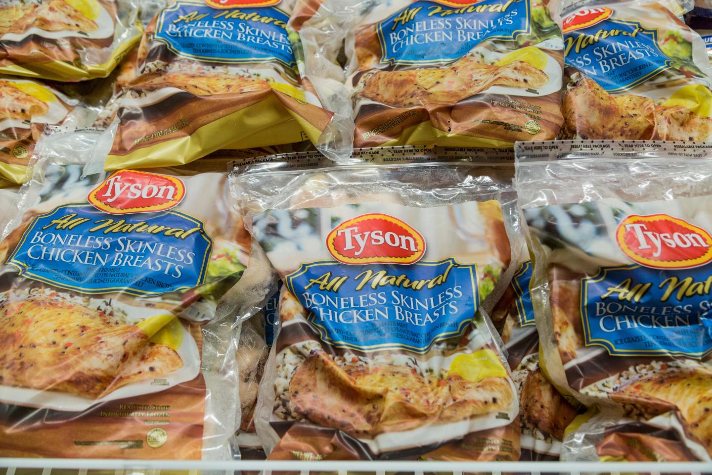 bags of Tyson brand frozen chicken breasts in the freezer case of a grocery store