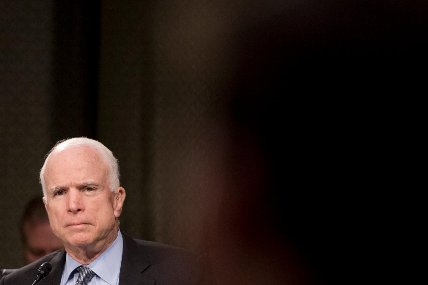 Senator John McCain sits in his chair on the Senate Intelligence Committee and looks skeptical