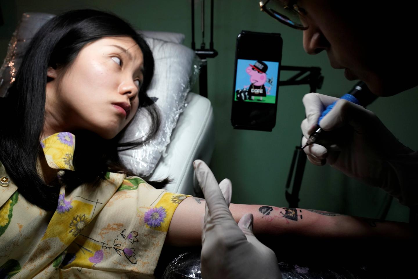 Woman gets a Peppa Pig tattoo at Samurai Tattoo studio in Shanghai