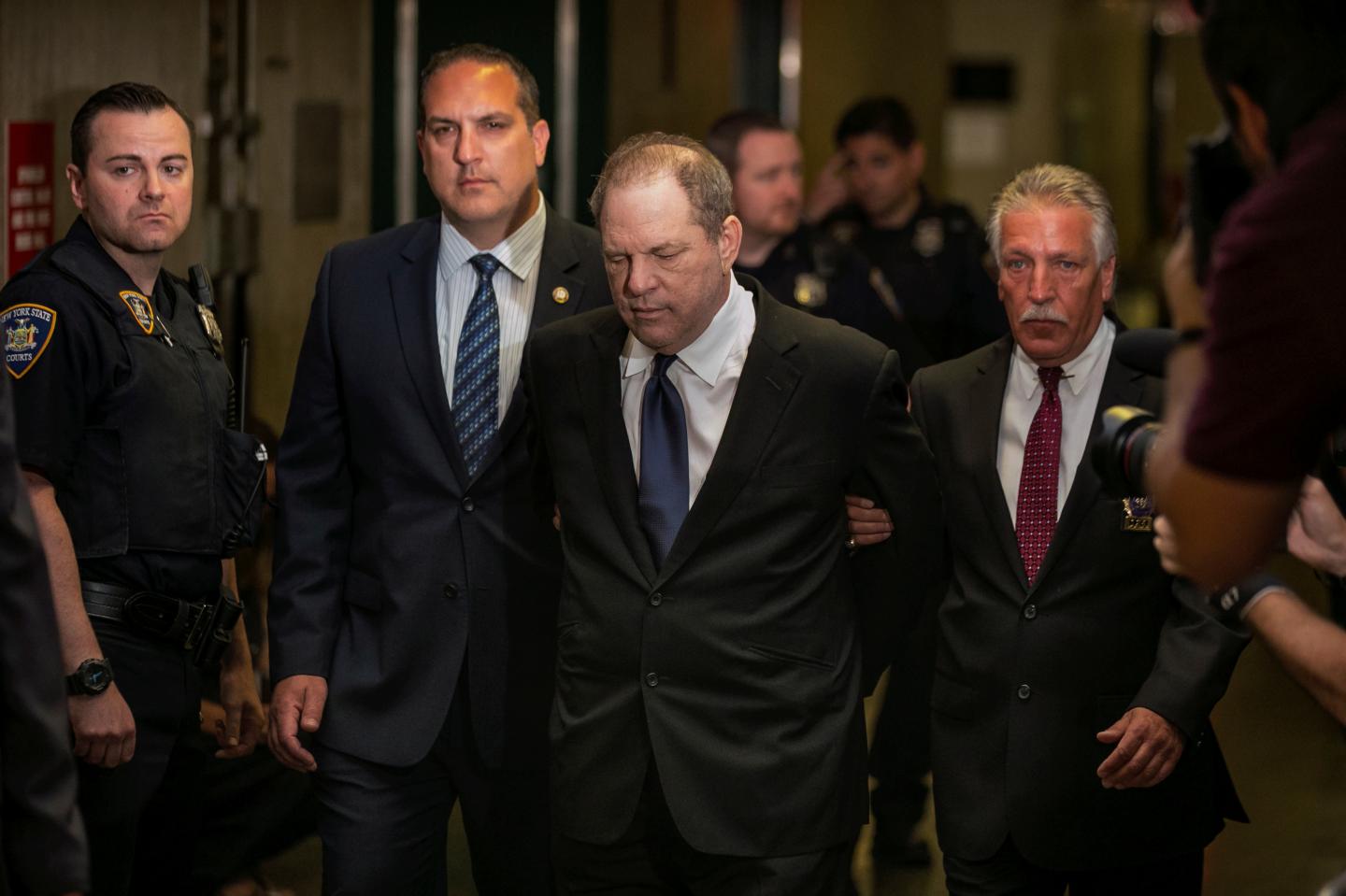 Film producer Harvey Weinstein is led handcuffed by police into his hearing at Manhattan Criminal Court in New York