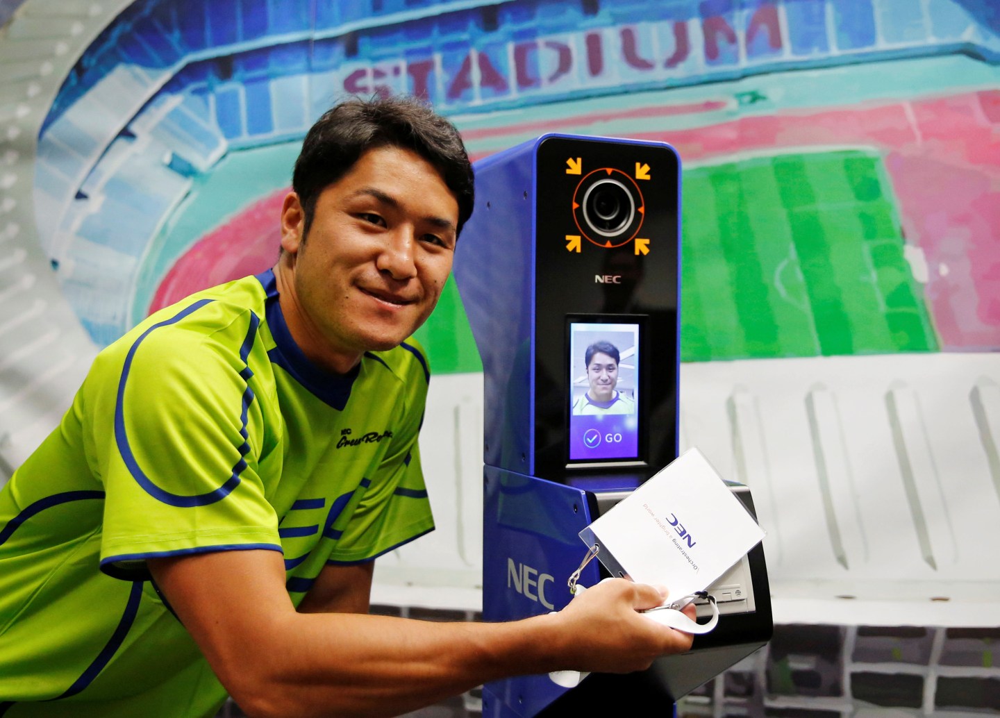 NEC Green Rockets' rugby player Teruya Goto poses with the face recognition system for Tokyo 2020 Olympics and Paralympics, which is developed by NEC corp, during its demonstration in Tokyo