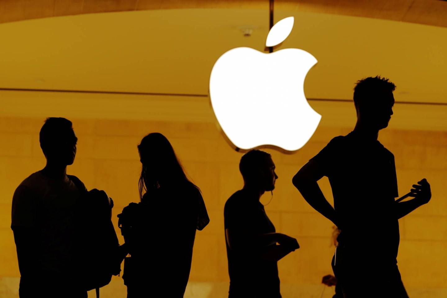 Customers walk past an Apple logo inside of an Apple store at Grand Central Station in New York