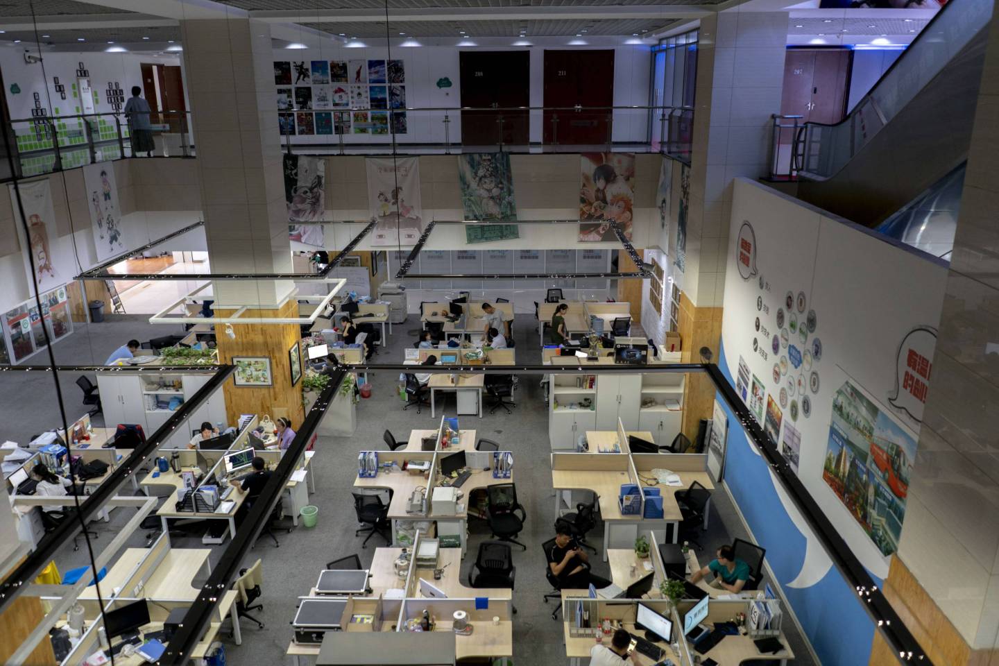 Young people are working in an open office space, which is a