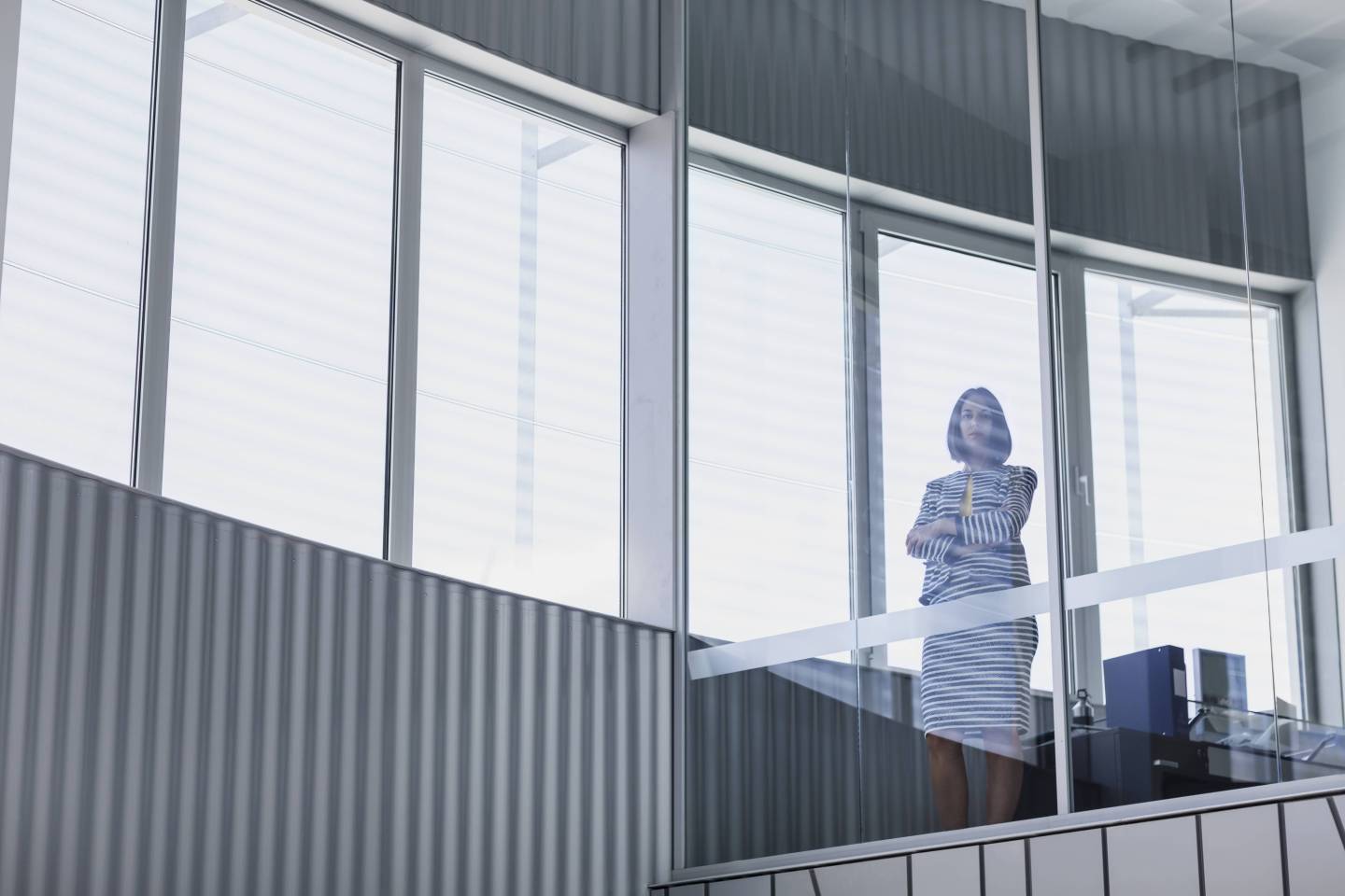 Portrait confident CEO businesswoman standing at modern office window