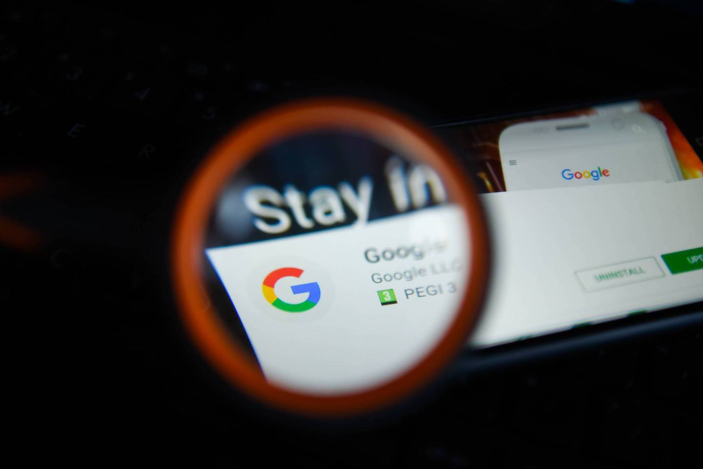 Google logo is seen trough a magnifying glass on an android