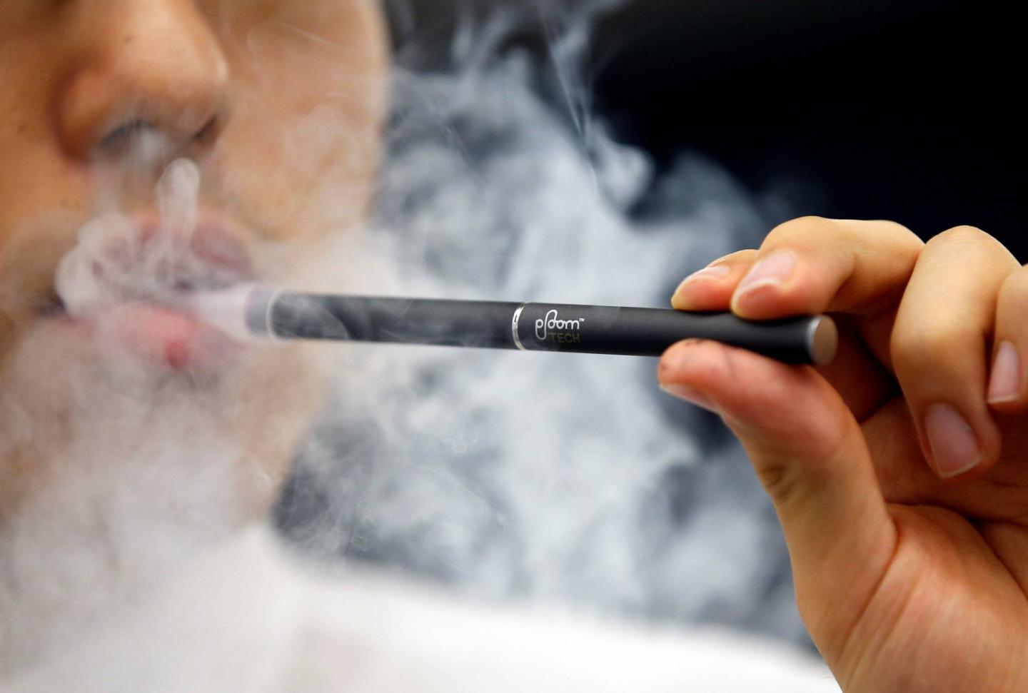 A shop assistant demonstrates a Japan Tobacco Inc's Ploom Tech smokeless vaping product at its Ploom Shop in Tokyo