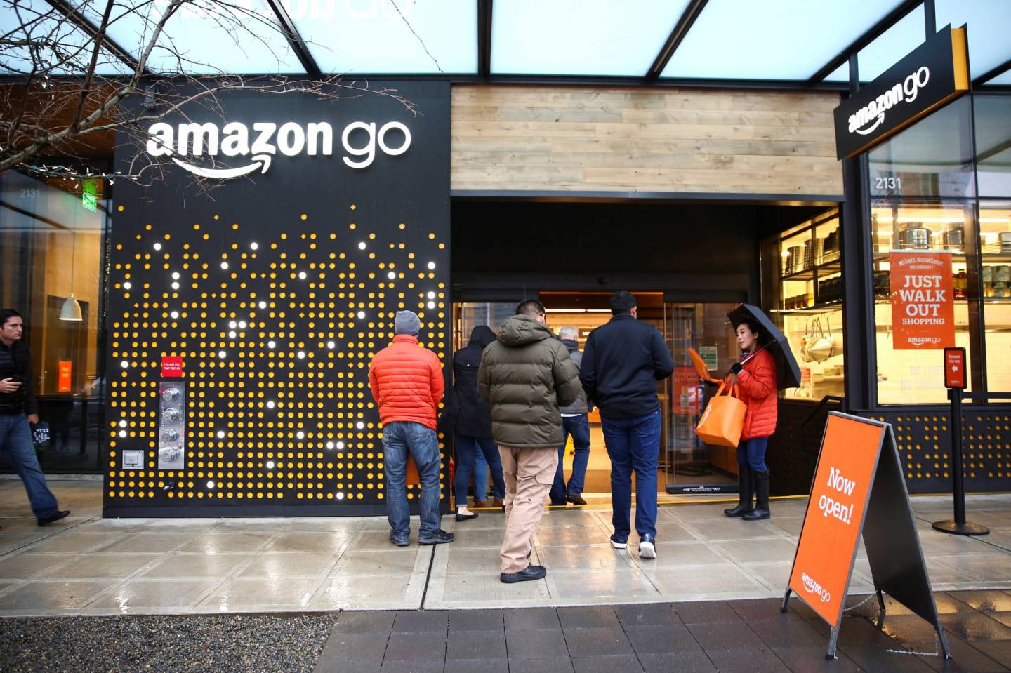 People are offered free reusable bags as they enter the new Amazon Go store in Seattle