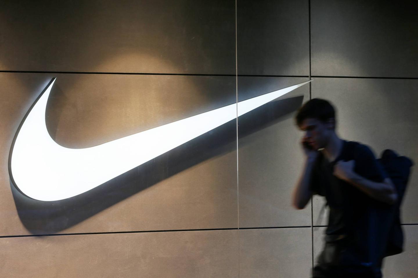 A man speaks on his mobile phone as he walks past a Nike store in central Kiev