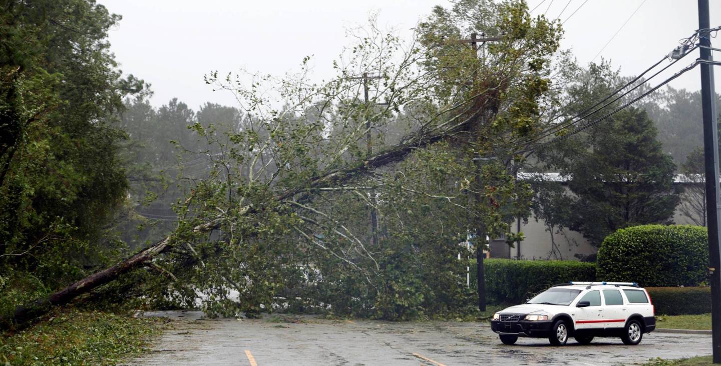 A motorist navigates away from a fallen tree blocking a road after the arrival of Hurricane Florence in Wilmington, North Carolina