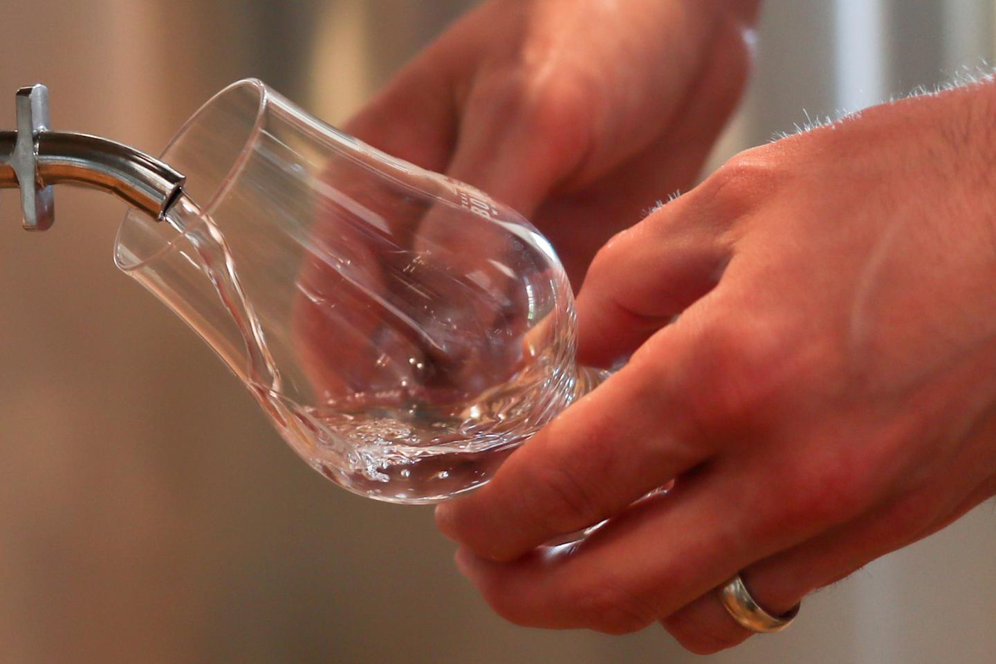Man samples White Dog whiskey at Firestone & Robertson Whiskey Ranch in Forth Worth, Texas