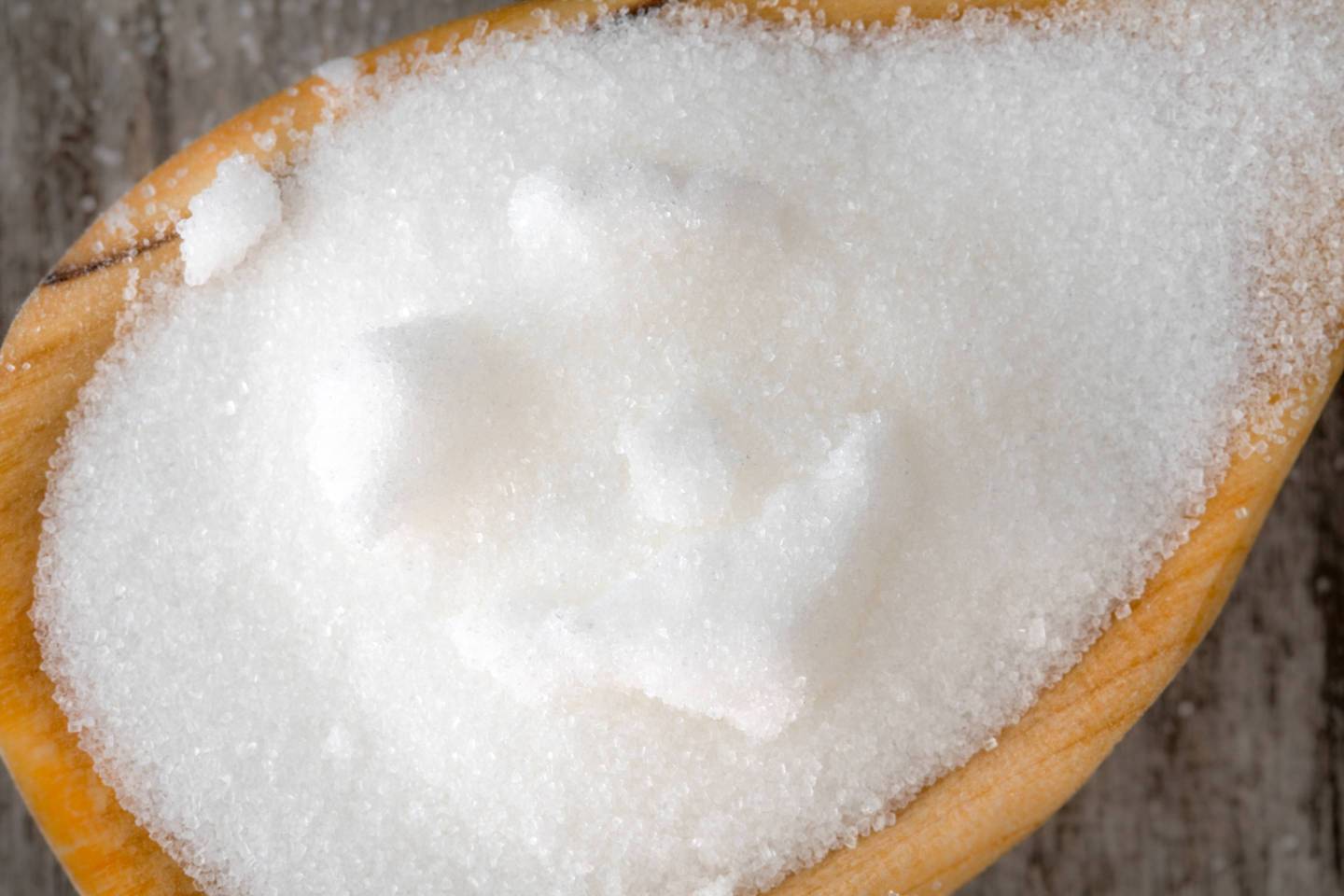 White sugar: close-up of the unhealthy food inside a wooden