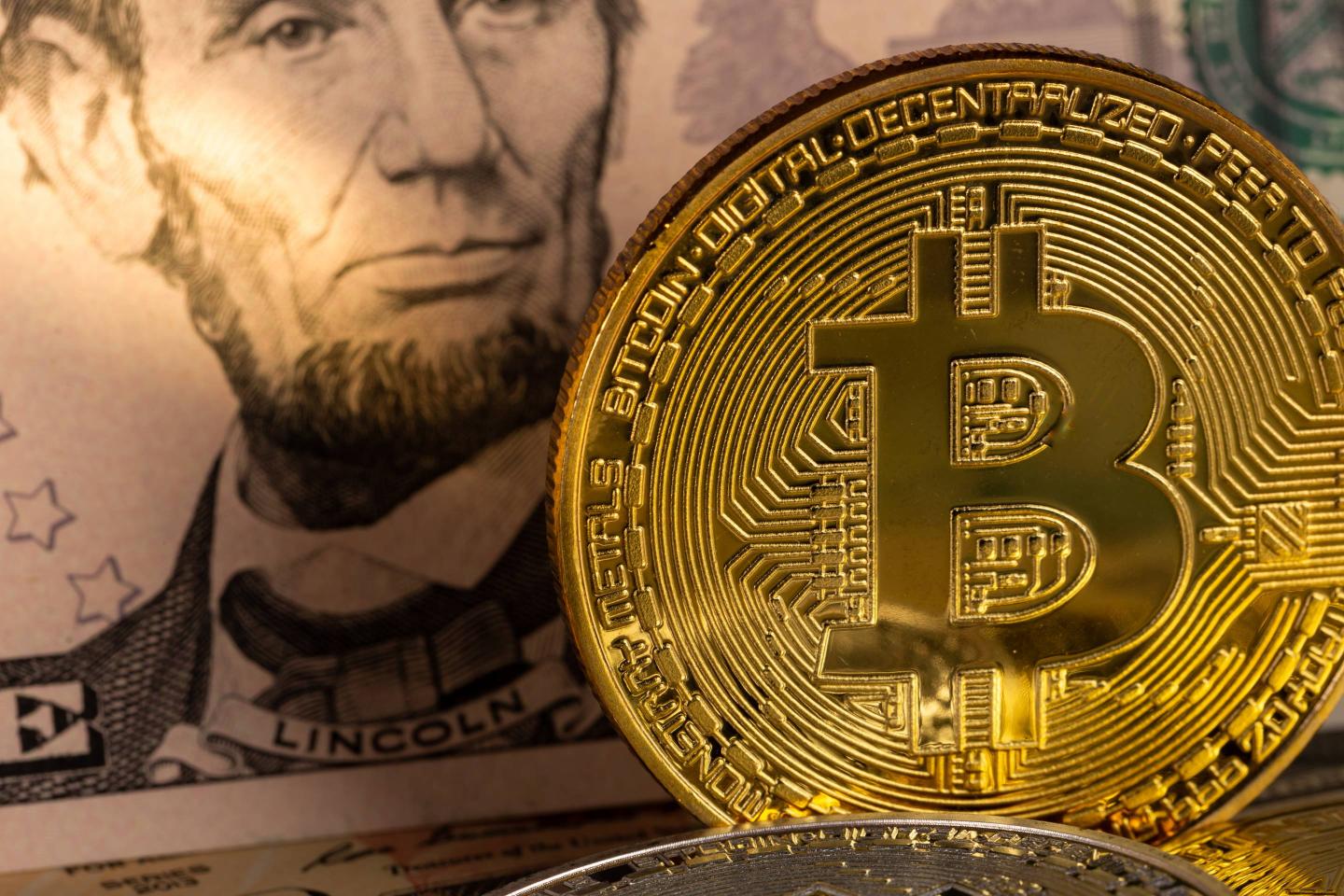 golden bitcoin coin on us dollars close up