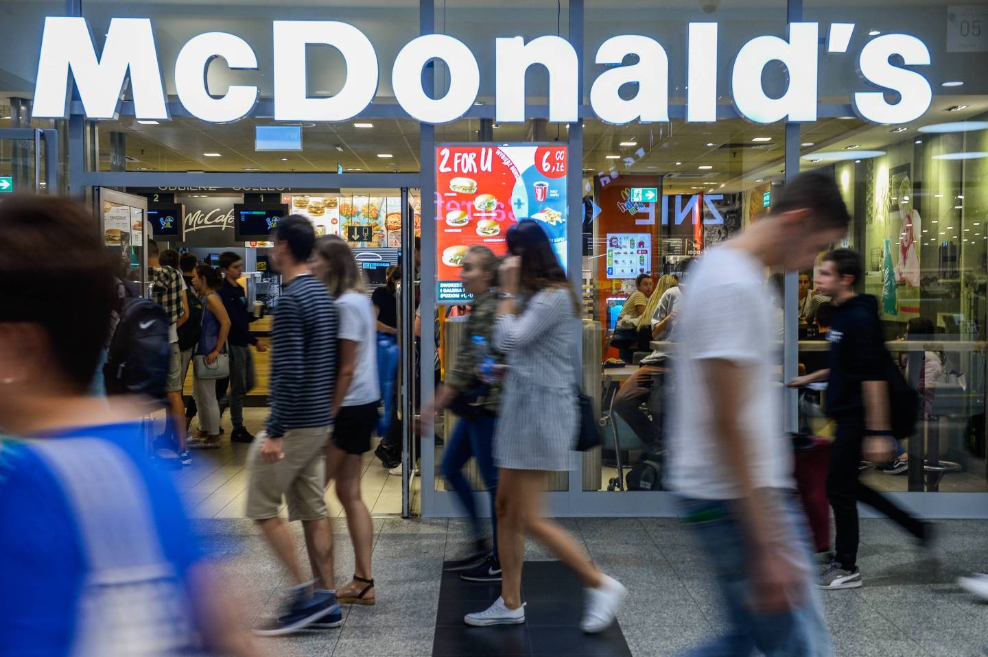 People seen walking by a Mcdonald's restaurant