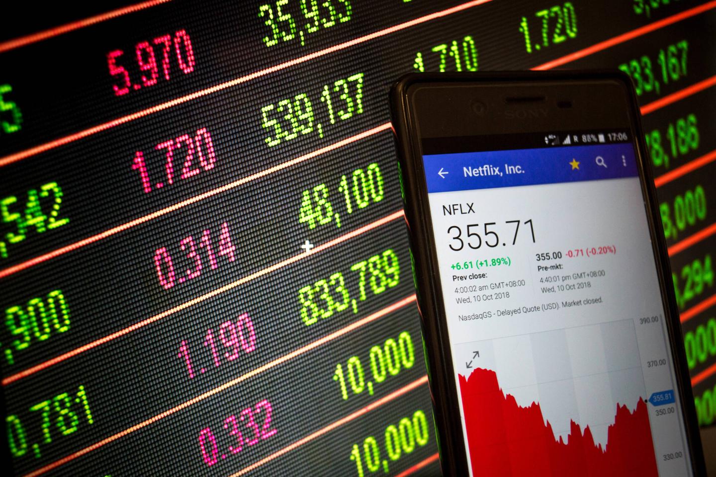 A smartphone displays the Netflix, Inc. market value on the