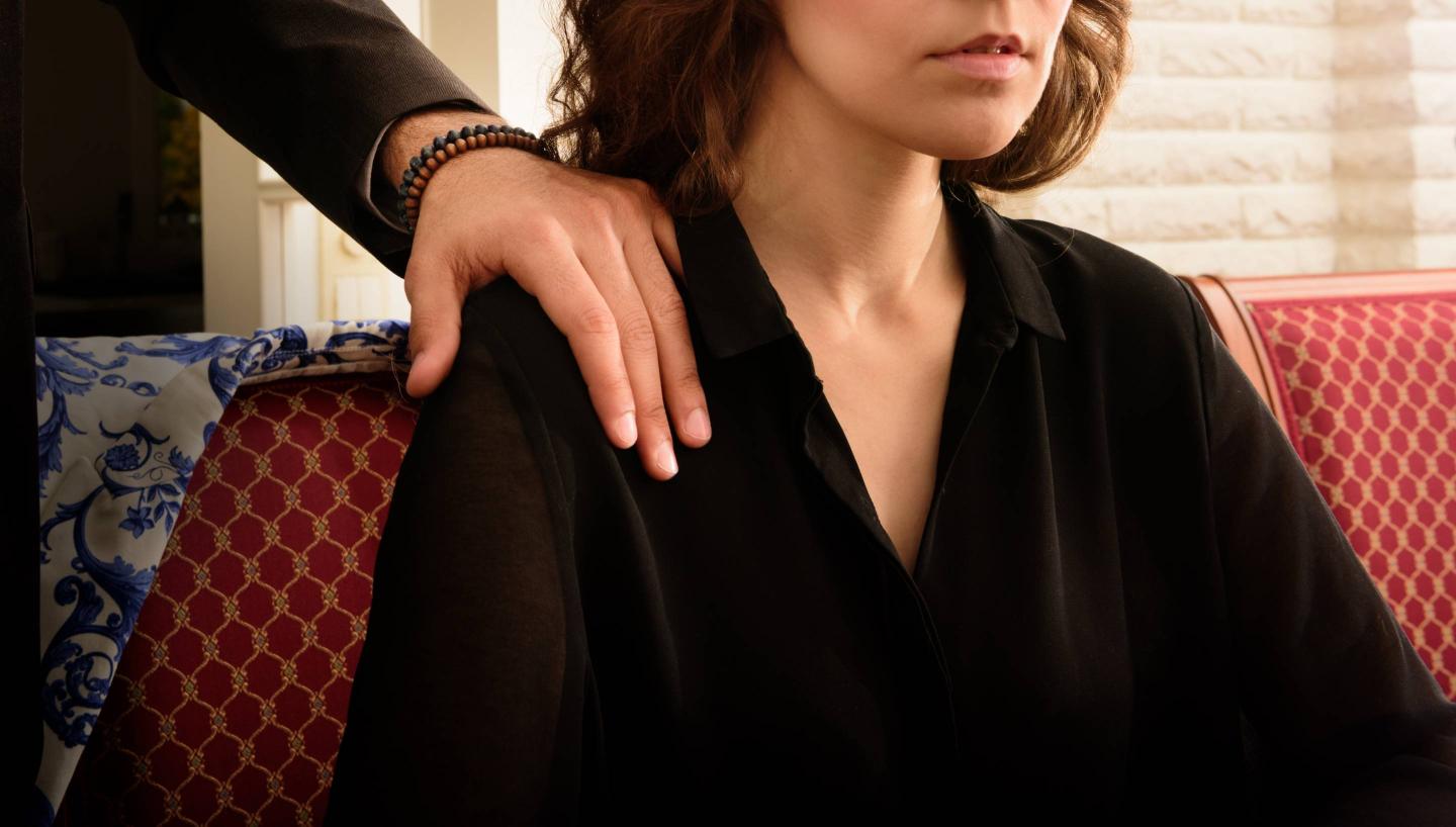 Troubled harrassed woman dislikes his hand. She wears ring.
