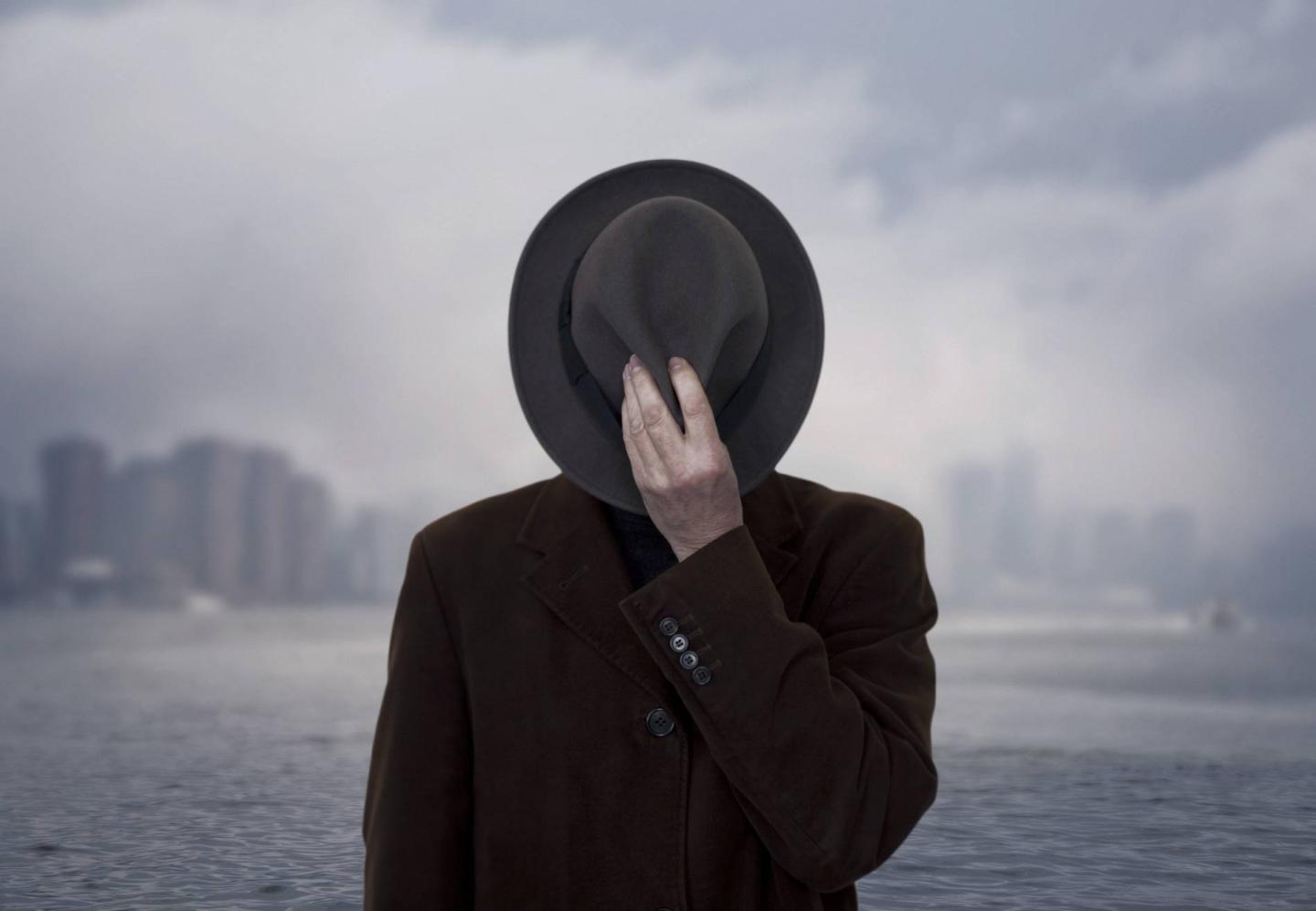 Portrait of a man with face covered by the hat.