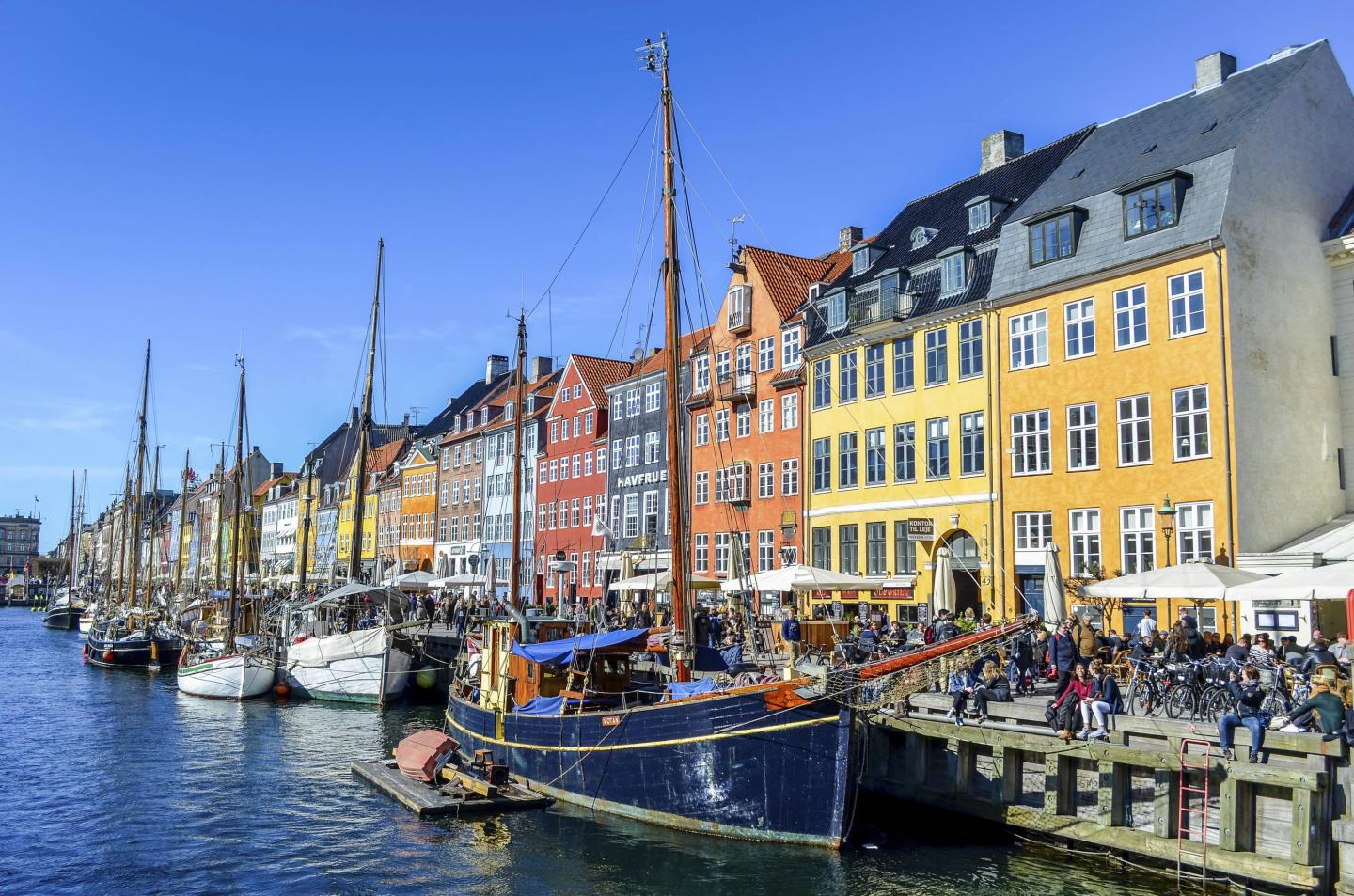 Nyhavn, the 17th century waterfront with row of colourful historic buildings, promenade and moored sailing ships in Copenhagen, Denmark.