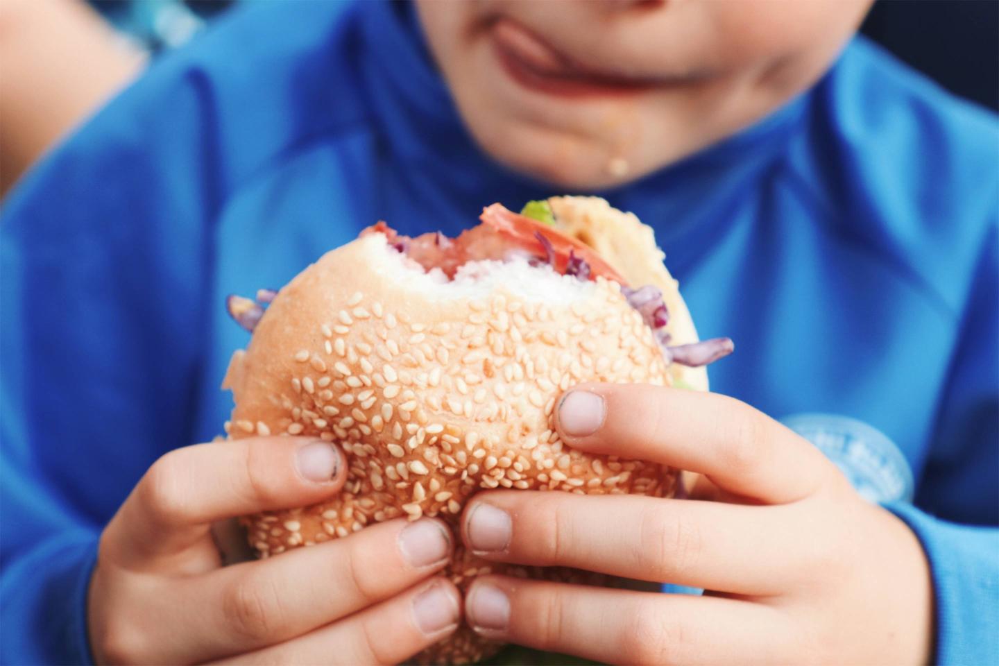 Midsection Of Boy Holding Burger
