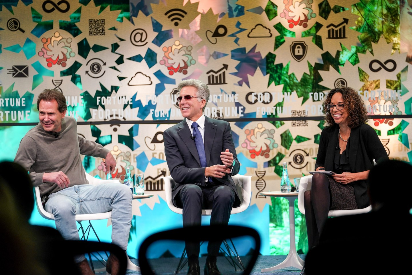 Dan Schulman (left), Bill McDermott (center), and Ellen McGirt (right) sit on stage laughing at Fortune's Global Forum.
