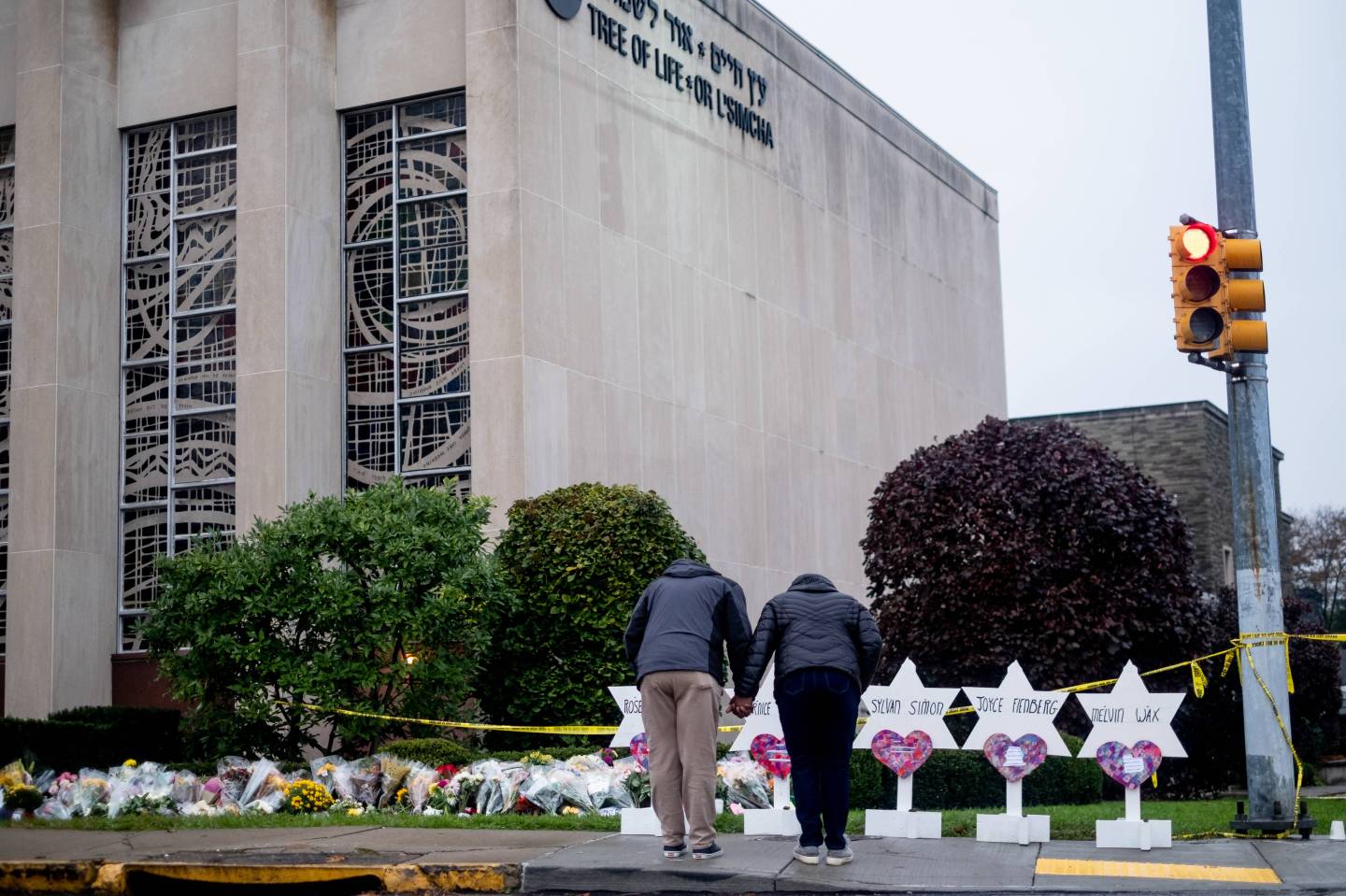 Mourners seen praying in front of the makeshift memorial at the Tree of Life synagogue.
