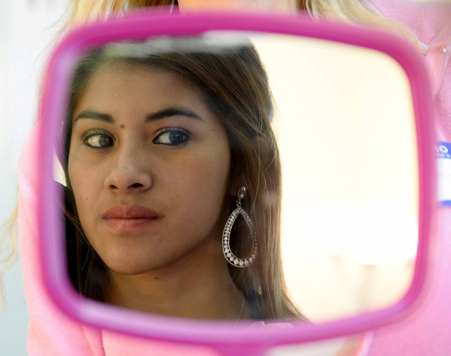 Monge tries an ear ring to match her prom dress at the Assistance League of Southern California headquarters in Los Angeles