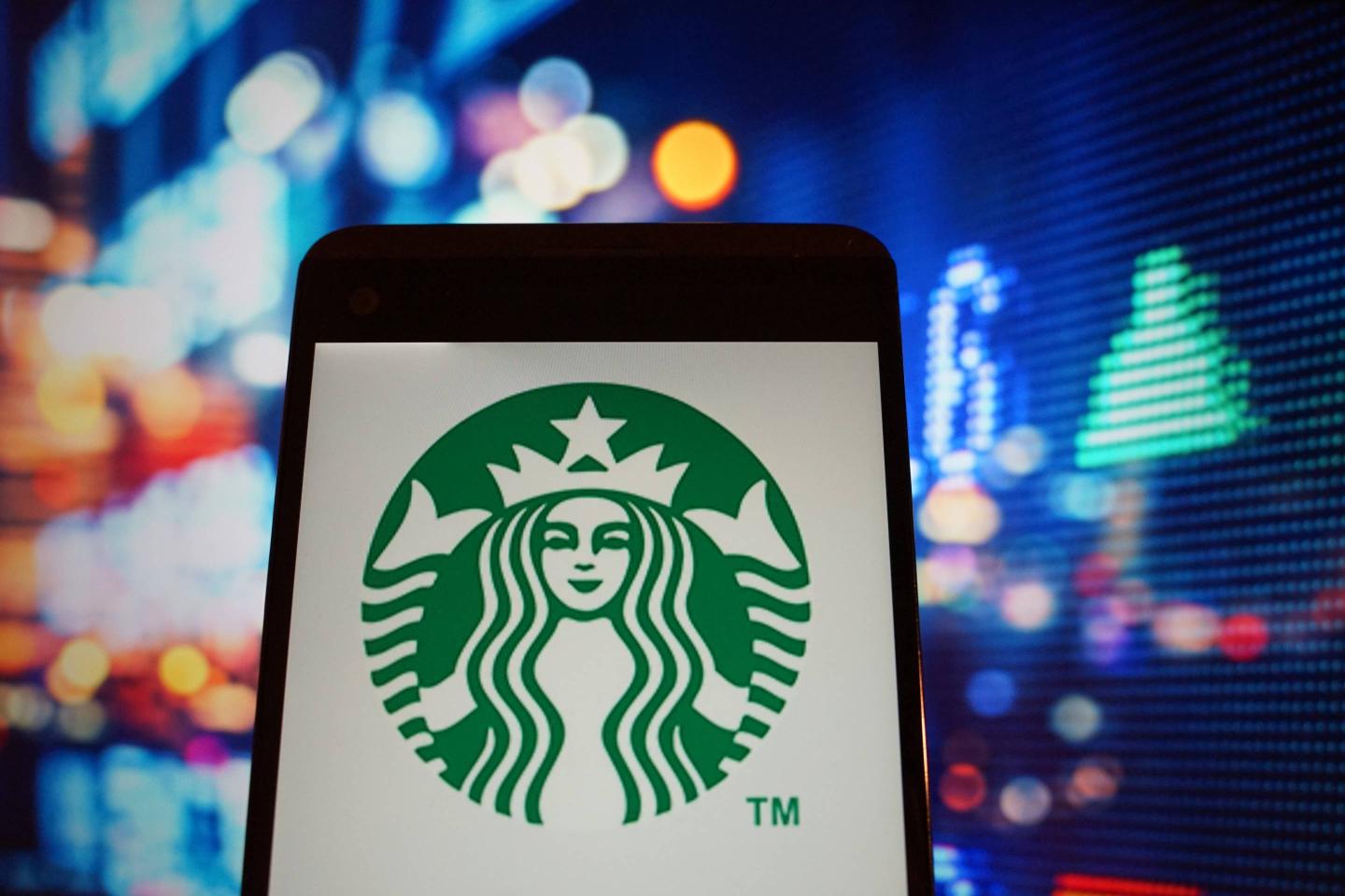 The logo of  Starbucks is seen in a smartphone