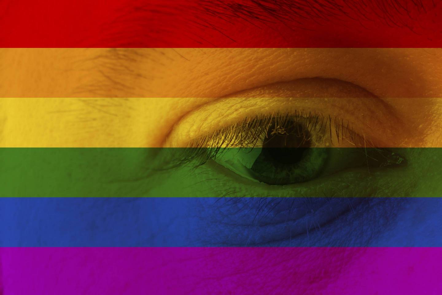Human face and eye painted with flag of LGBT movement