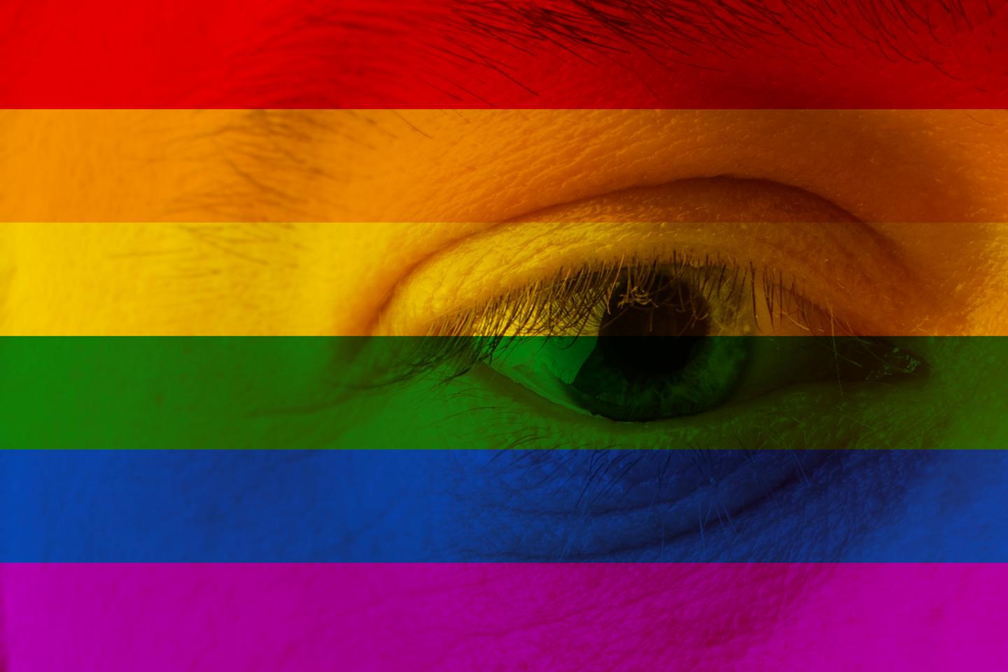 Human face and eye painted with flag of LGBT movement