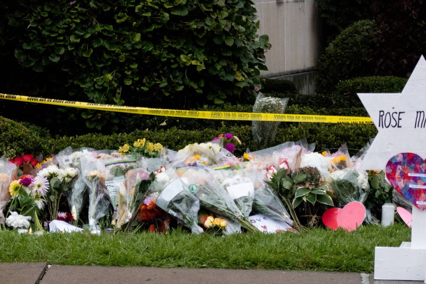 Roses and flowers sit at a makeshift memorial in Squirrel Hill