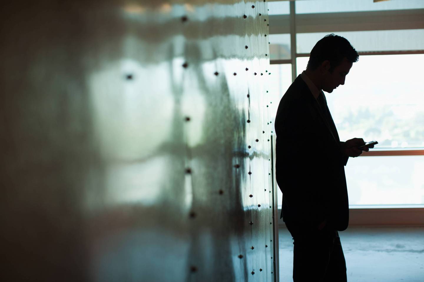 Silhouette of businessman using cell phone