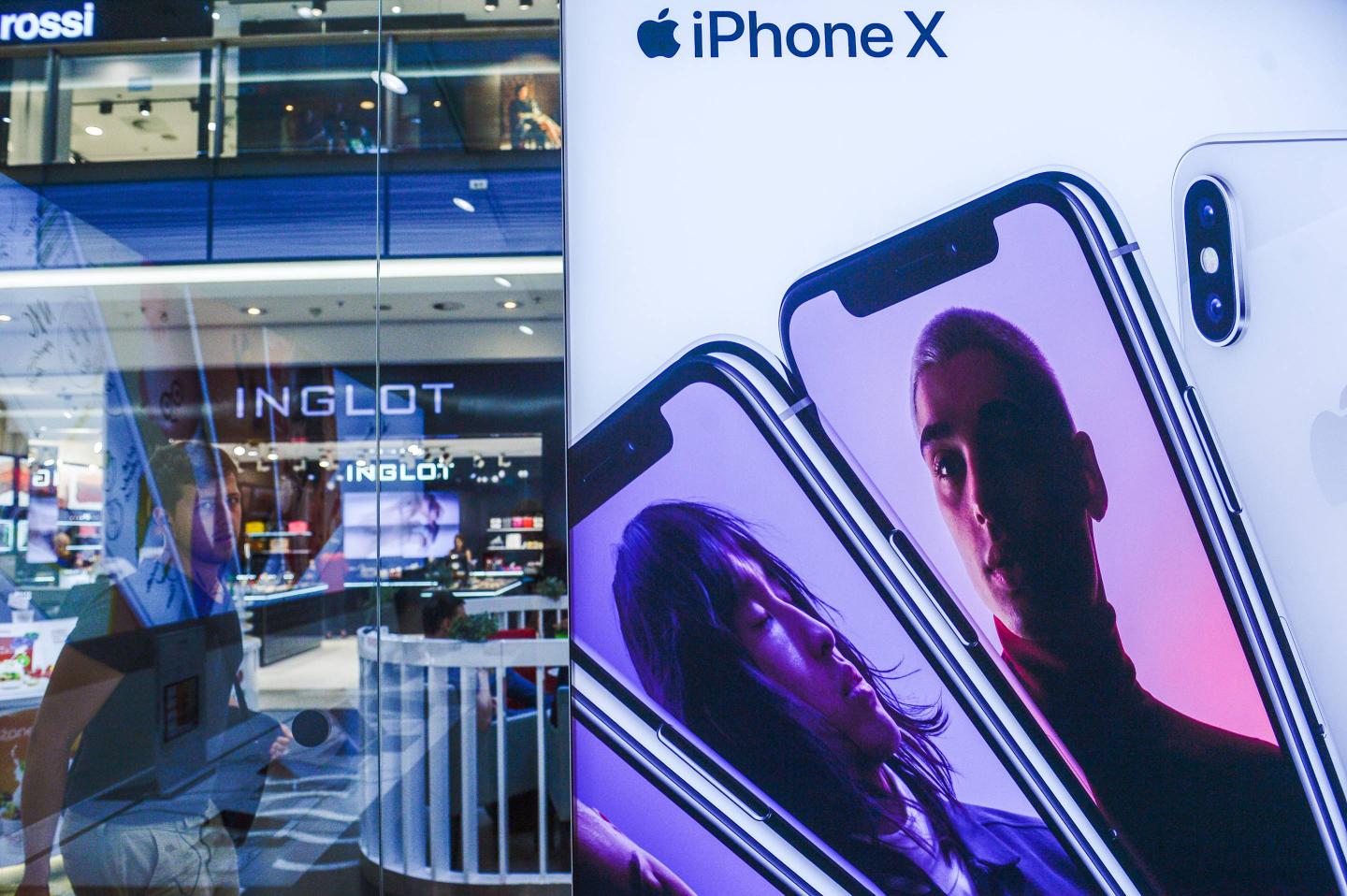 A man seen walking by an iPhone X advertisement