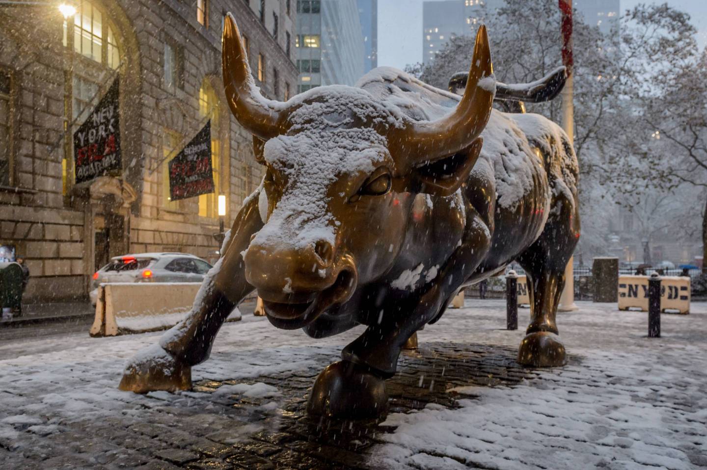 Wall Street Bull statue covered in snow as New York City was